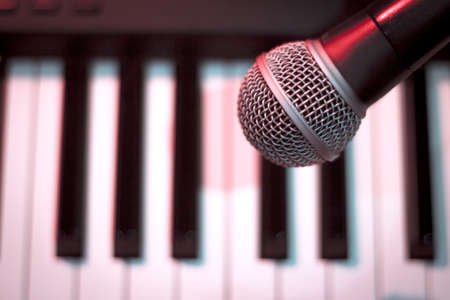 Microphone over piano keys in dim light. No peopleの写真素材