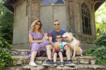 Family consisting of parents and two children. Sitting on some stairs.の写真素材