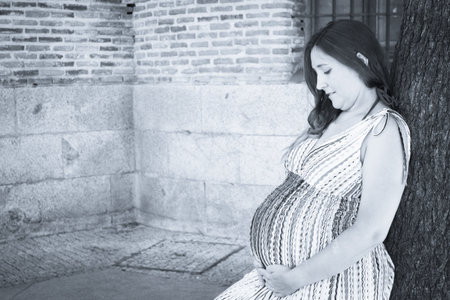 Seven month pregnant woman outdoors in multi colored striped dress. Day sceneの写真素材