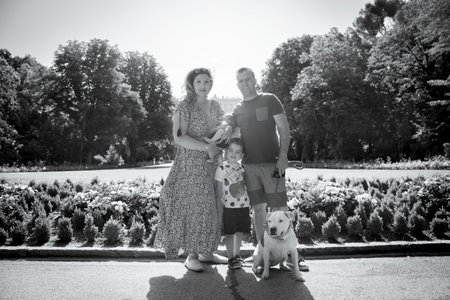 Family posing standing composed of parents, two children and a dog. Summer day.の写真素材