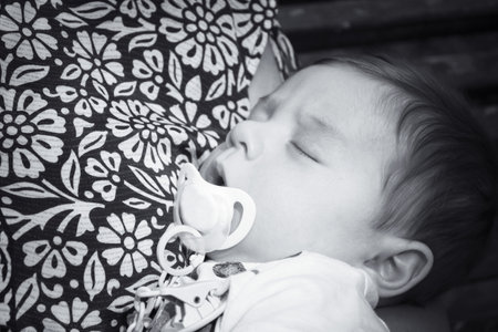 Baby sleeping in his mothers arms. sweet scenes