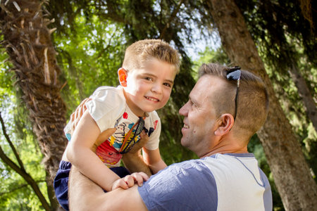Father with son holding him up in the air. Smilingの写真素材