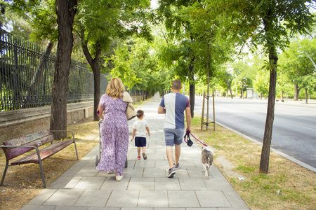 Family walking through the streets seen from behind. day sceneの写真素材