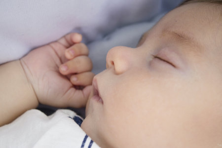 Two month old baby sleeping with hand next to face. Relax sceneの写真素材