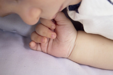 Two month old baby hand. blue backgroundの写真素材