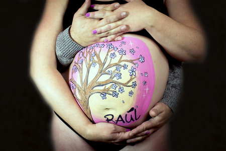 Family scene with pregnant mother and father hugging. No copy spaceの写真素材