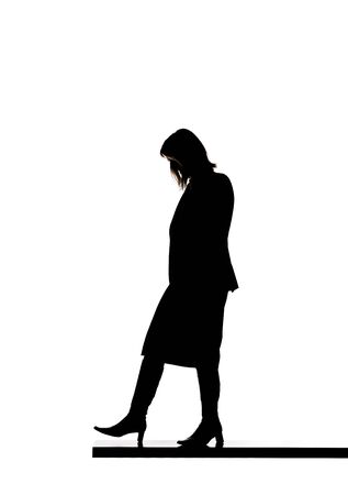 Silhouette of a woman walking on a boardの写真素材