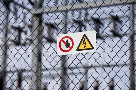 Warning signs on a fence with short focal depth.