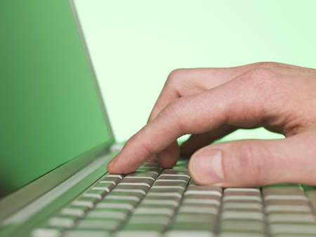 closeup on a hand writing on a laptop keyboard