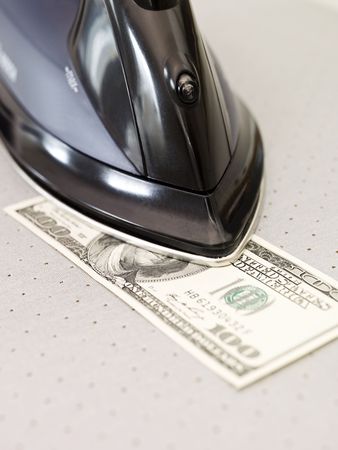Human ironing a Hundered dollar bank noteの写真素材