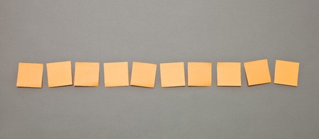 Orange Adhesive Notes in a rowの写真素材