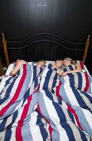 Family sleeping in the same bedの写真素材