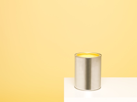 Paintcan with spill on yellow backgroundの写真素材
