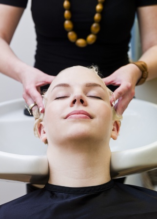 Hairdresser washing customers hair at a Beauty Spaの写真素材