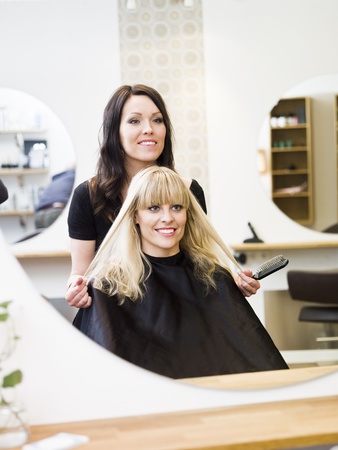 Hairdresser in action with blond customer close upの写真素材