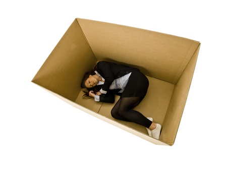 Woman sleeping in a cardboard box isolated on white backgroundの写真素材