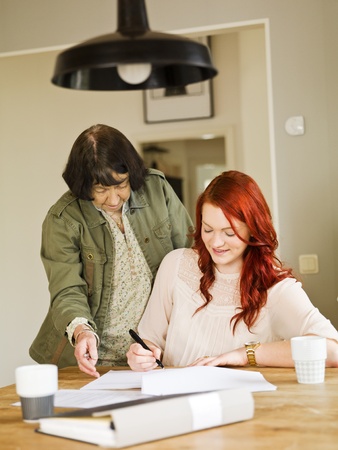 Grandmother helping her grandaughter with paperworkの写真素材