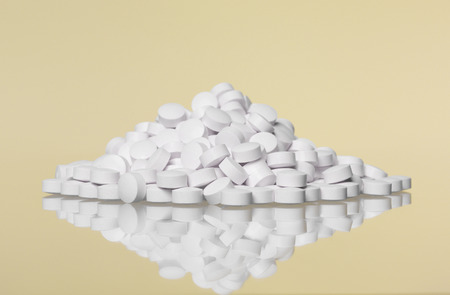Stack of pills towards Yellow backgroundの写真素材