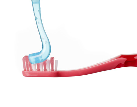 Red toothbrush and blue toothpaste isolated on white backgroundの写真素材
