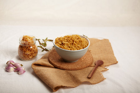Noodle and Fried Onions ready to eat for garnish on the chopping board and spoon on the top view . Copy space for textの写真素材