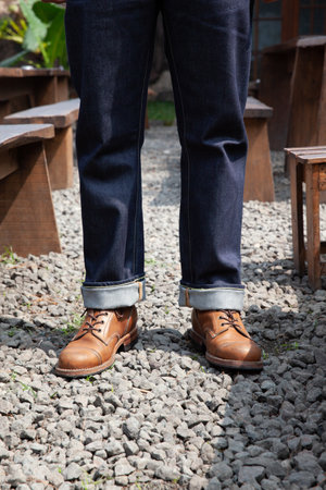 Men wearing leather boots and blue denim jeans standing on rocksの写真素材