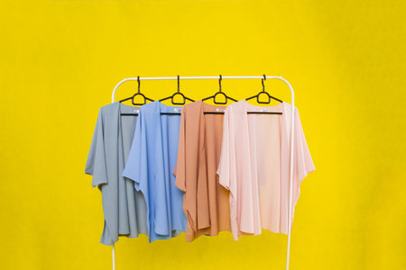 Clothes hanging on a hanger on a yellow background. Minimal concept.の写真素材