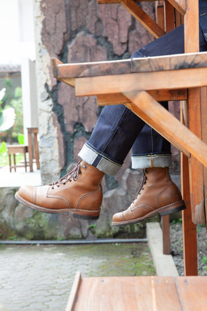 Men wearing leather boots and blue denim jeans standing on stair