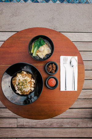 Bakmi or Mie Ayam in black bowl isolated on white. Indonesian cuisine noodles meat dish. Traditional asian food and meal. Top viewの写真素材