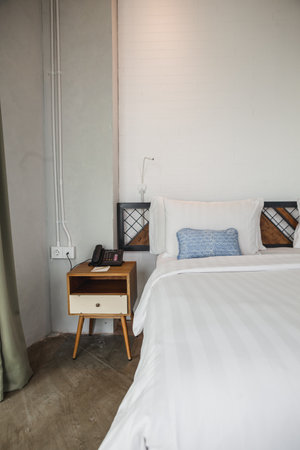 Cozy minimalism hotel room with wooden table on the corner of the room. White wall give you comfort and fresh while in the room.の写真素材