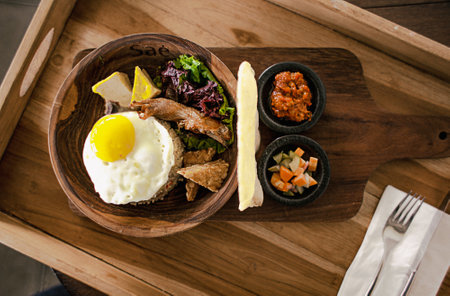 Fried Fice with Chicken, Tofu, Sunny Side. Prepared and served in a Wooden Bowl. Natural wood in the background. Top view.の写真素材