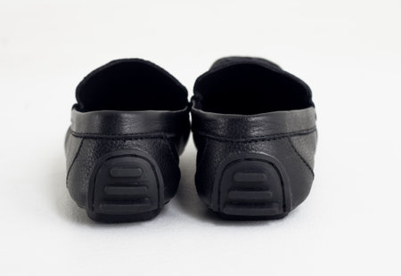 A pair of black baby shoes on a white background, isolated.の写真素材