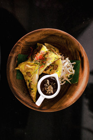 Indonesian Omlete, served with bean sprouts, sweet sauce on wooden bowl and top viewの写真素材
