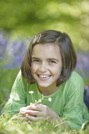young girl lying in a wood full of bluebellsの写真素材