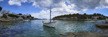 Panorama of small boats moored in the Mediterranean cove of Cala Alcaufar,Menorca,の写真素材