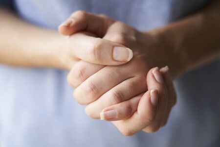 Close Up of a Woman rubbing her hands together with disinfectant の写真素材