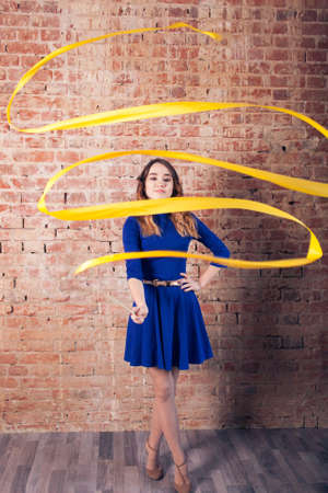 Girl gymnastics with a yellow ribbon. Blue dressの写真素材
