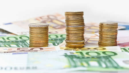 Stacks of  Euro coins on banknote money background の写真素材