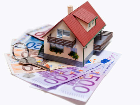 House with Euro banknotes and house key over white backgroundの写真素材