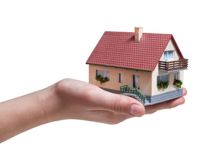 Hand holding small miniature house isolated on white backgroundの写真素材