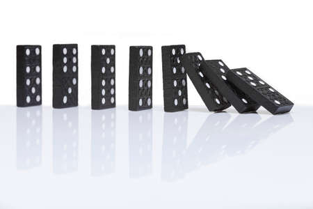 row of dominoes with one falling overの写真素材