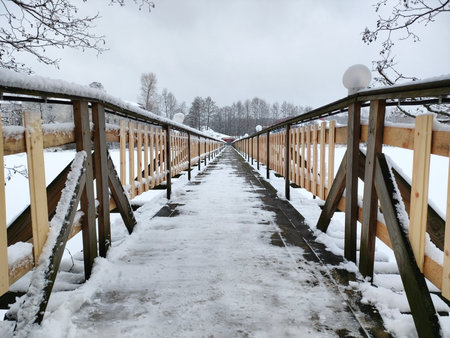 A small pedestrian bridge across the lake in winter frozen ice snow Vladimir regionの写真素材