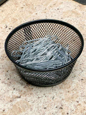 Black wire bowl of sliver paper clips . High quality photoの写真素材