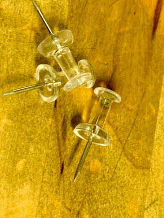 Push Pins in a pile on wooden desk . High quality photo