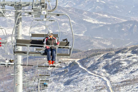 Skier on ski lift at resort in Siberia