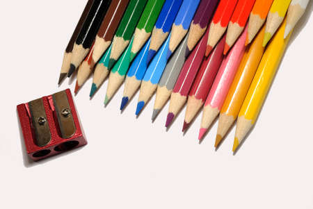 Colored pencils with sharpener on a white background
