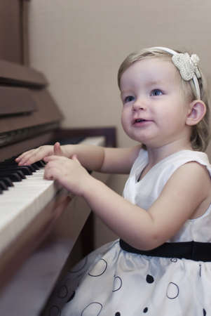 A little girl learns to play the pianoの写真素材