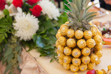 San Jose, CA - July 2, 2014: Ferrero Rocher candy wrapped all around a pineapple as a decoration...