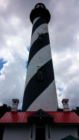 June 11, 2014 - black and white striped light house with cloudy sky located in St. Augustine, FL.のeditorial素材