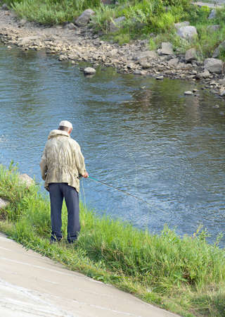The combination of urban and wild life, the old fisherman fishing rod in the urban canal.