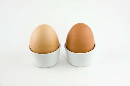 two eggs in cups isolated on a white backgroundの写真素材